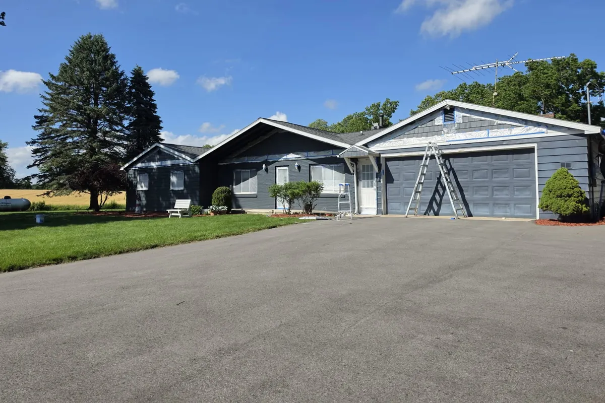Ranch home with a ladder against the wall during an exterior painting project