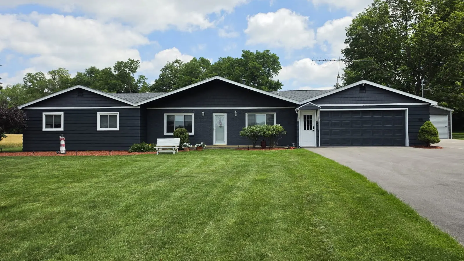 Ranch home painted dark navy with white trim after an exterior painting project